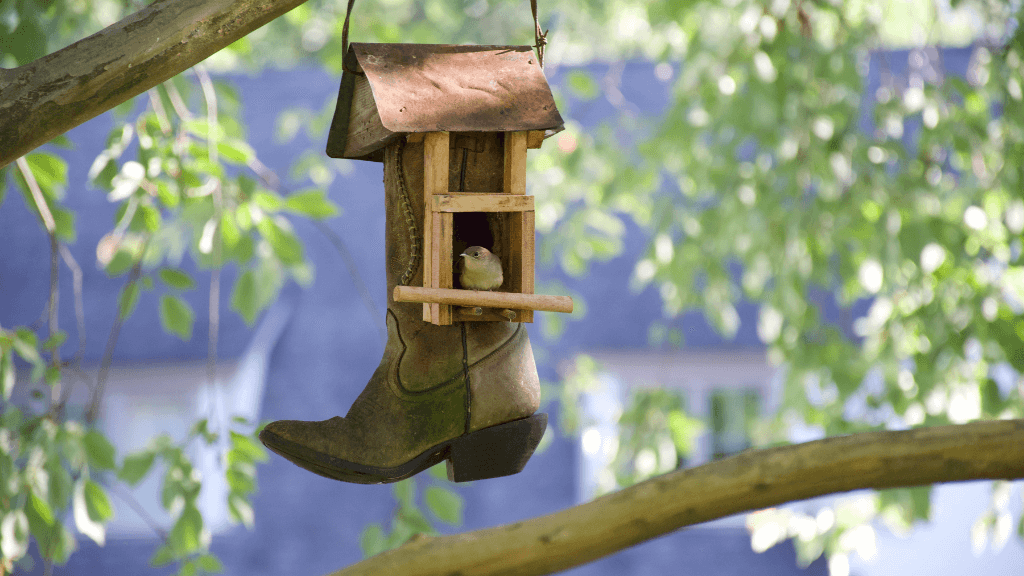 Oude laars verwerkt tot vogelhuisje met een vogeltje erin